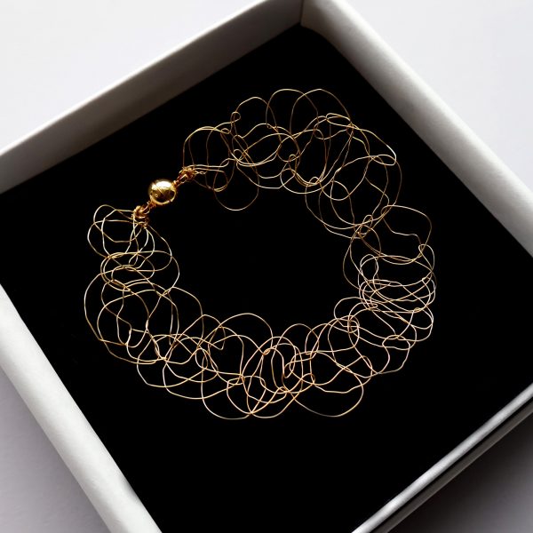 Bracelet Lumio, bijou en maille métallique or jaune, signé Marie Archambaud, marque de bijoux brodés uniques. Le bracelet est protégé dans son écrin haut de gamme.